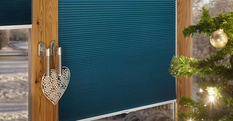 Türkises Plissee und Weihnachtsdeko Türkises Plissee an einem Fenster mit Weihnachtsdekoration