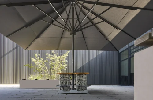 Moderner Außenbereich mit großem Sonnenschirm und Steintisch