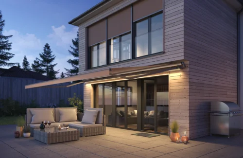 Moderne Terrasse mit gemütlicher Sitzgruppe und Beleuchtung bei Abenddämmerung