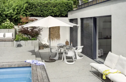 Moderne Terrasse mit Pool und stilvollen Gartenmöbeln