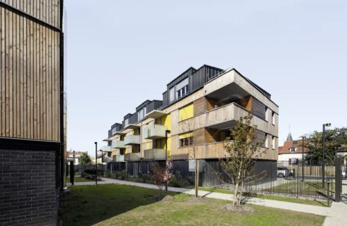 Modernes Mehrfamilienhaus mit Balkon und gelben Markisen - Basis-Markise