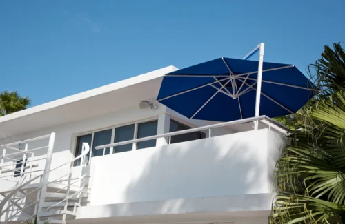 Moderne Villa mit blauem Sonnenschirm auf dem Balkon